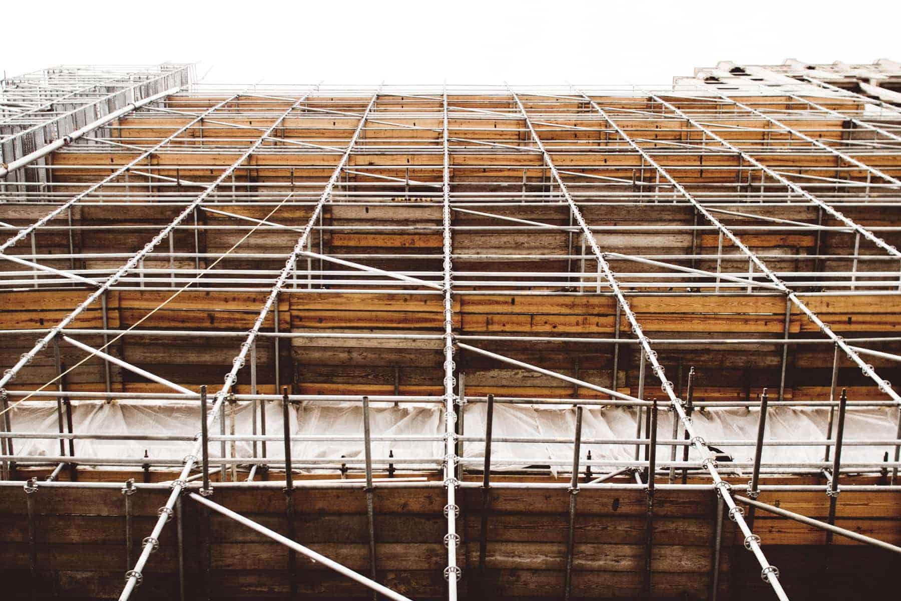 Looking up at a building in development with construction scaffolding.