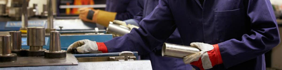 Workers in a manufacturing factory working on assembling a product with protective gloves.