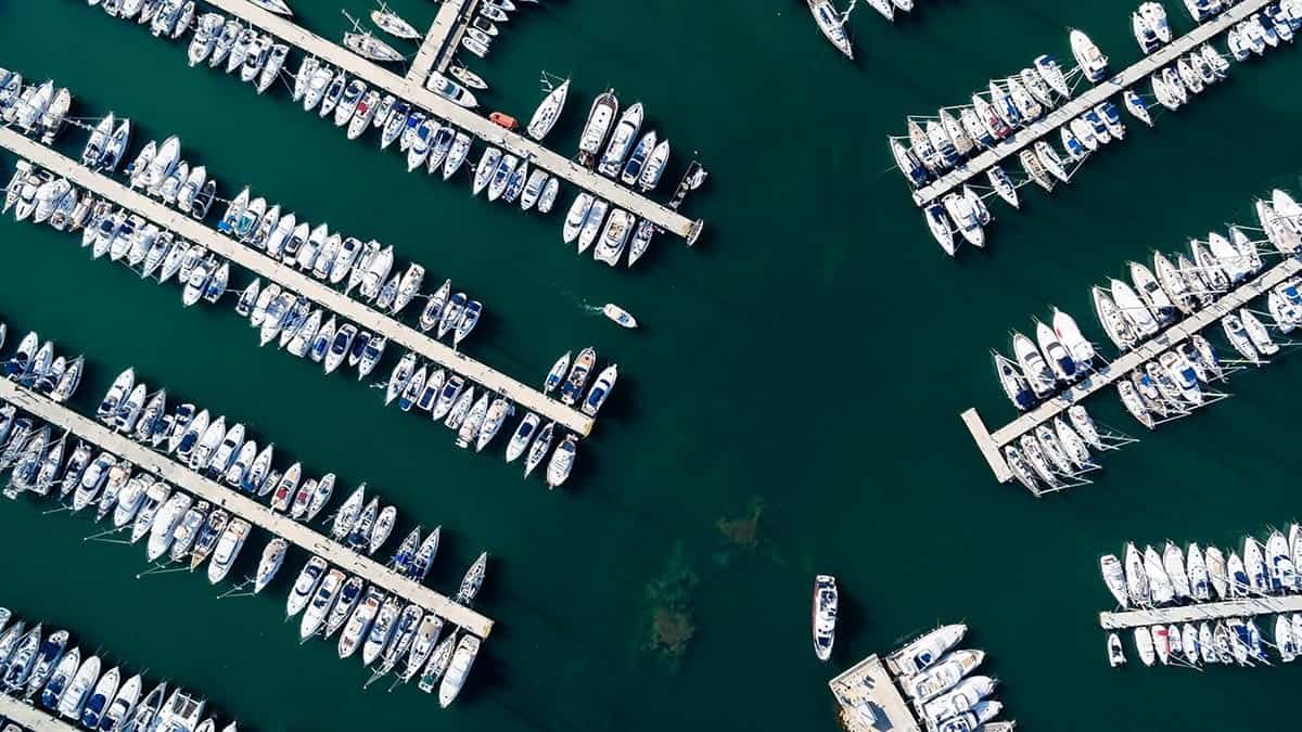 A birds eye view of many boats docked on a body of water.