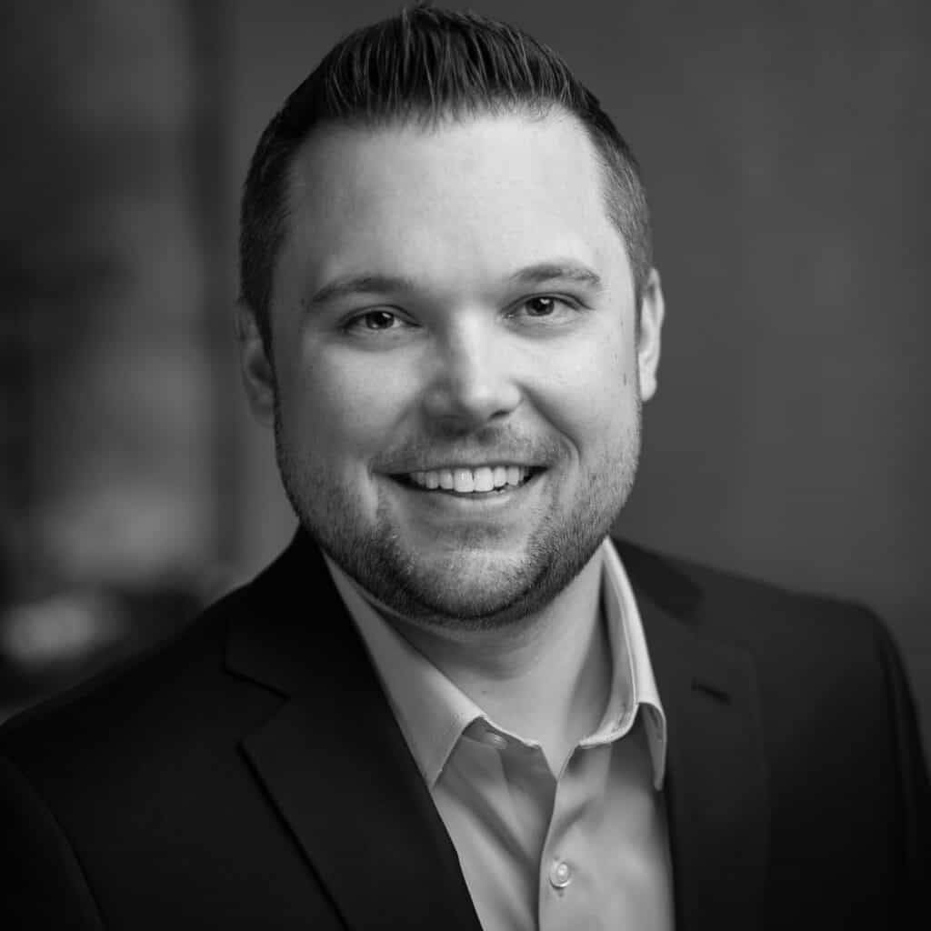 Eric Seifert's headshot in black and white in an indoor office space.