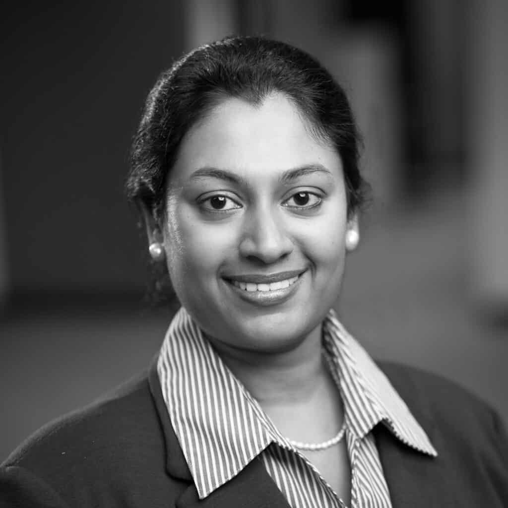 Sneha Sundaram's headshot in black and white in office space.