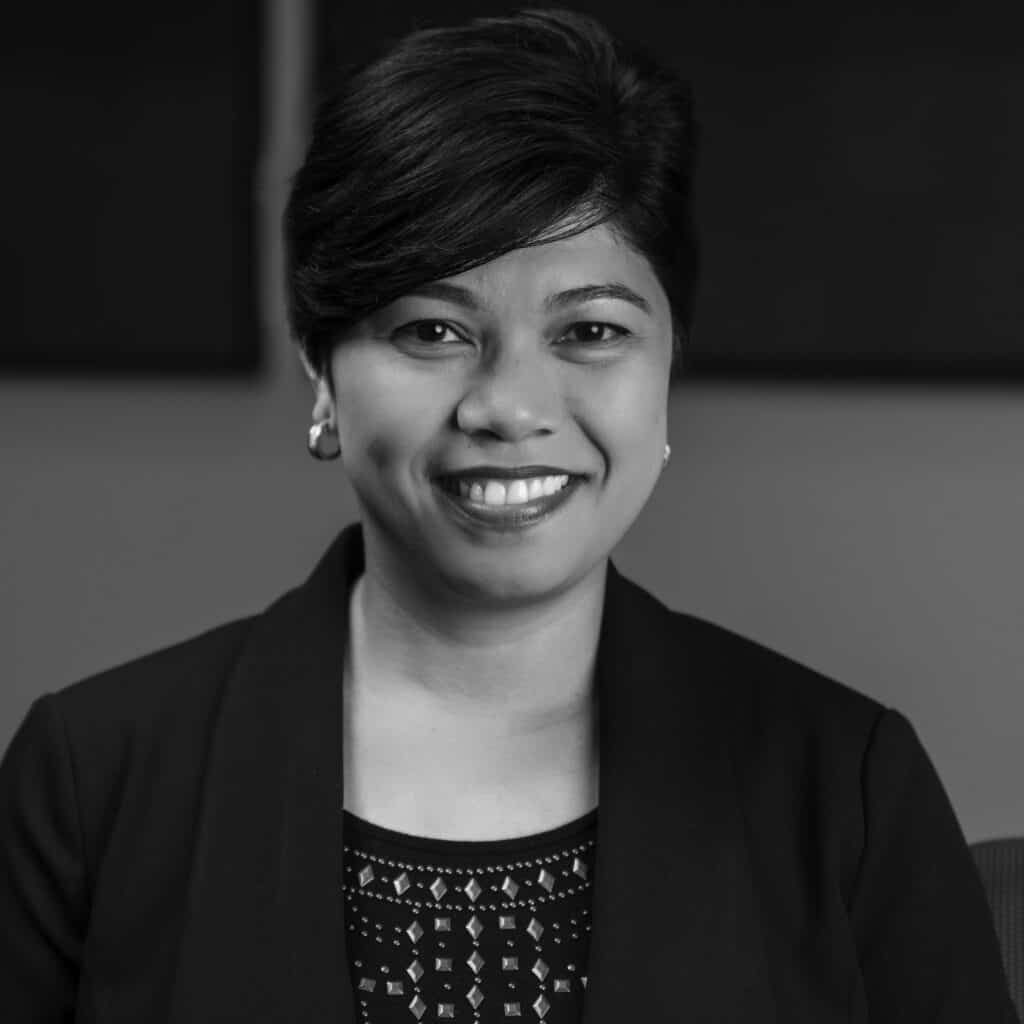 Edna Flores headshot in office space in black and white.