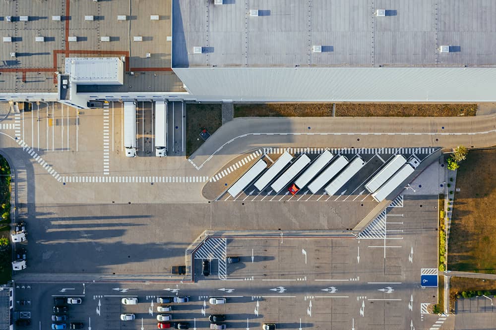 Aerial view of a parking lot with trucks and economy cars