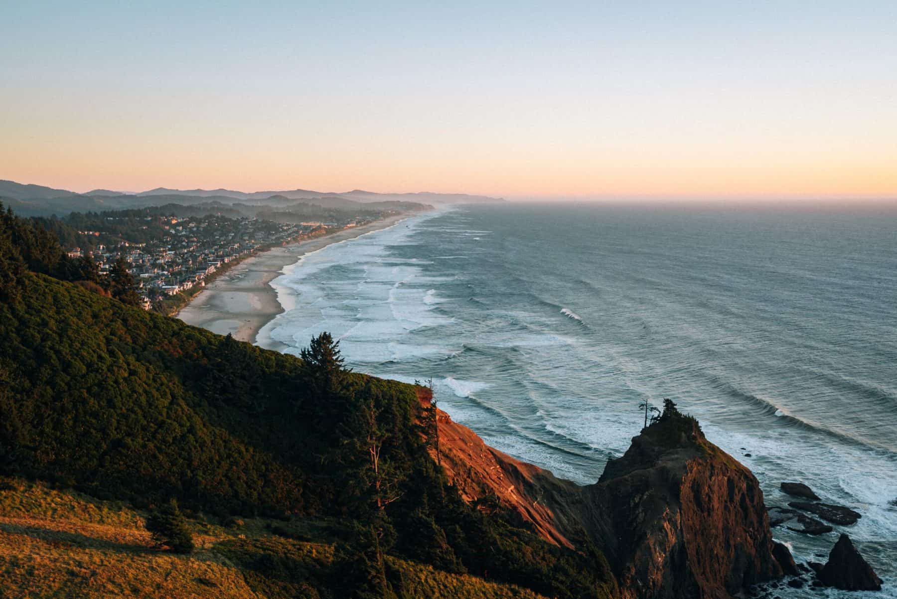 landscape photo of the ocean, beach, and cliff during an evening sunset