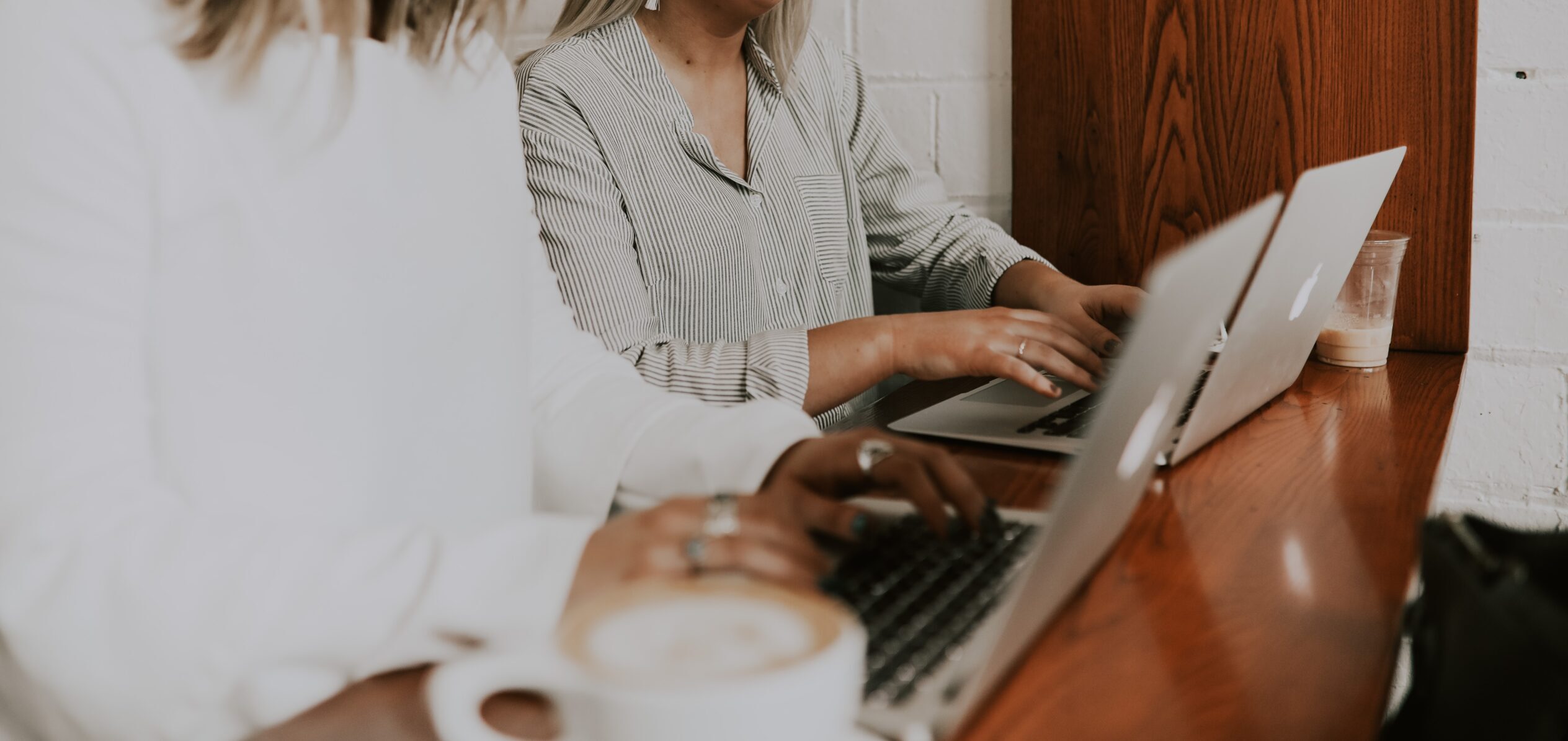 Two women work together on laptops to review M&A activity in Q1 2022.