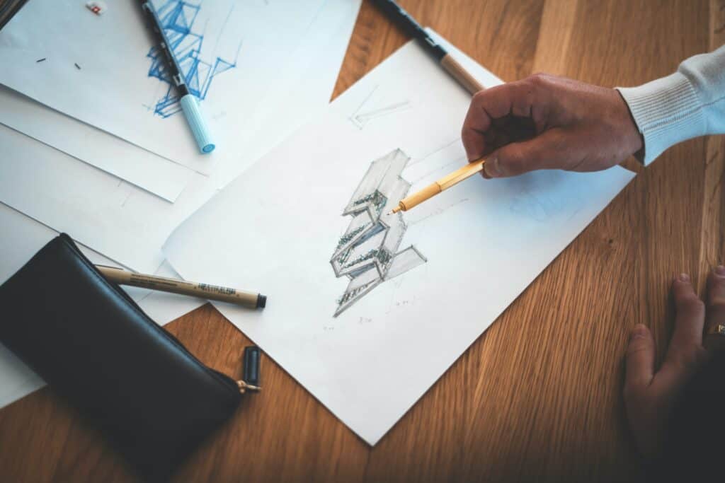 Construction employee reviews a building plan on a wooden desk.