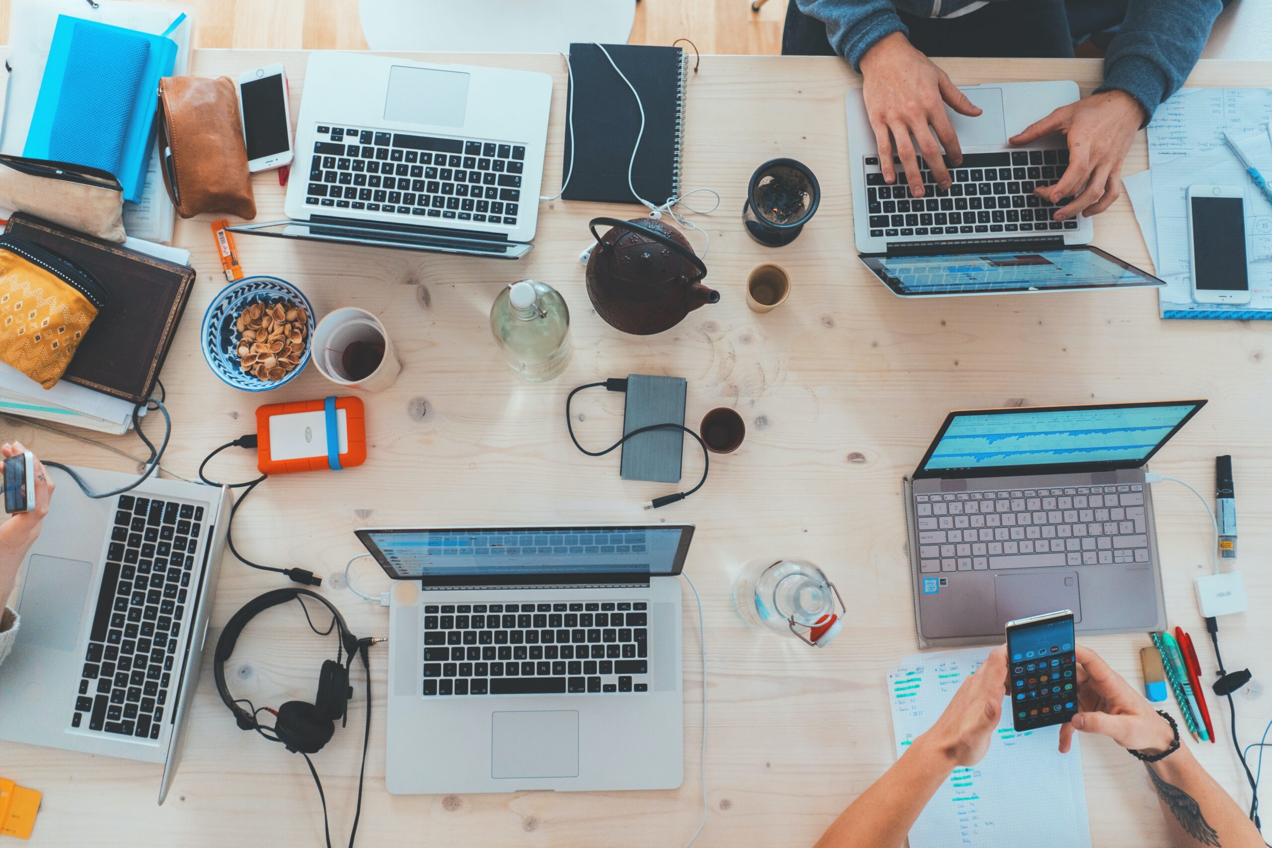 A team of nonprofit leaders discuss cybersecurity around a table with their laptops and snacks