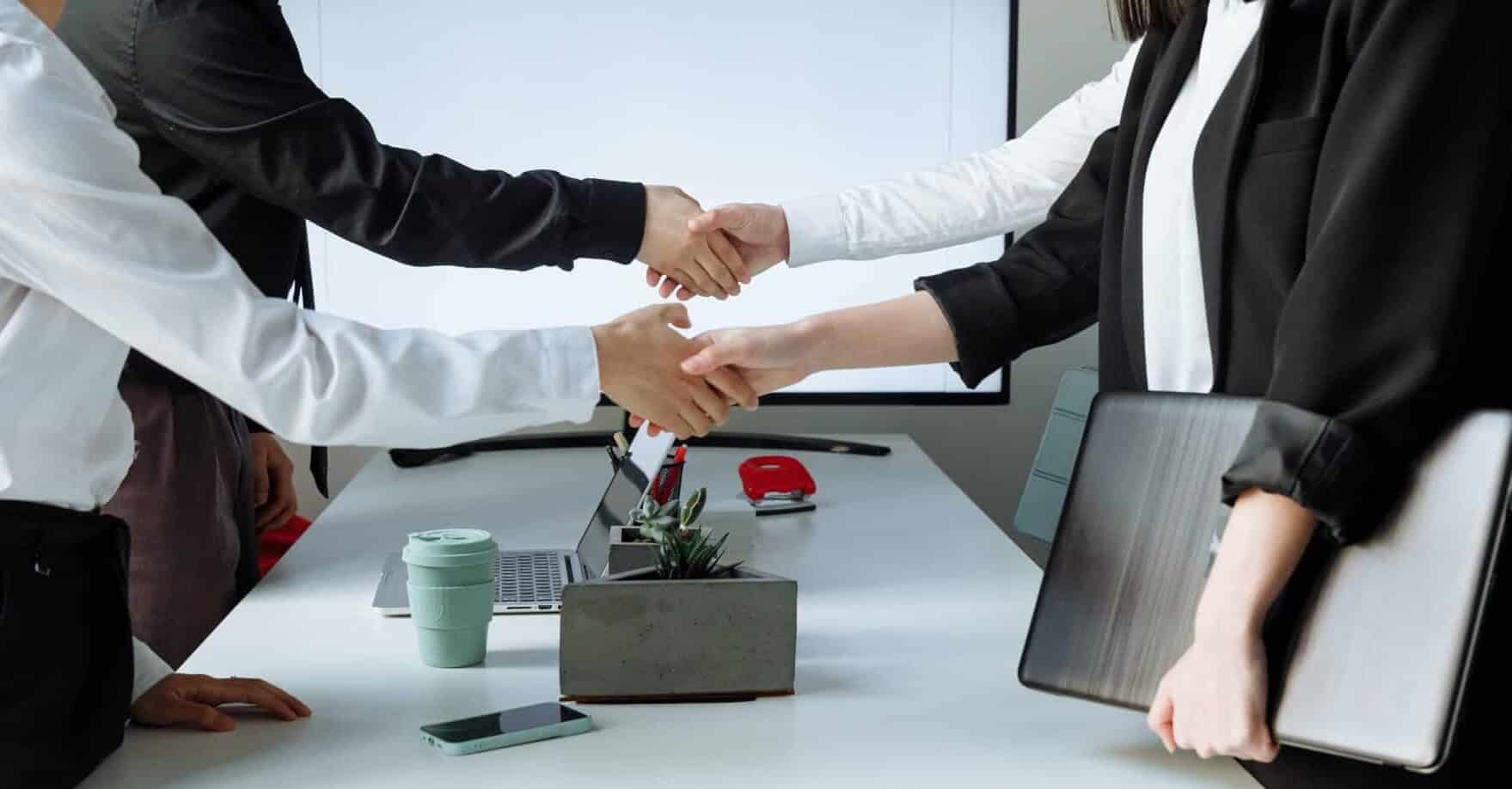 Business owners shake hands after negotiating and external sale