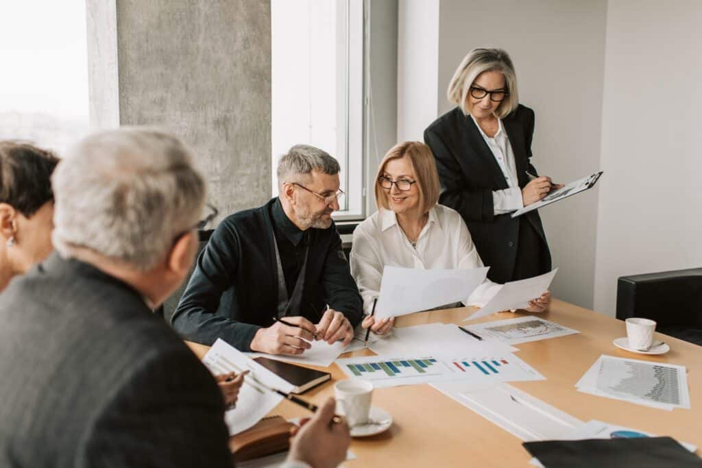 Business owner consult with their M&A advisor at a conference table with financial documents on the table